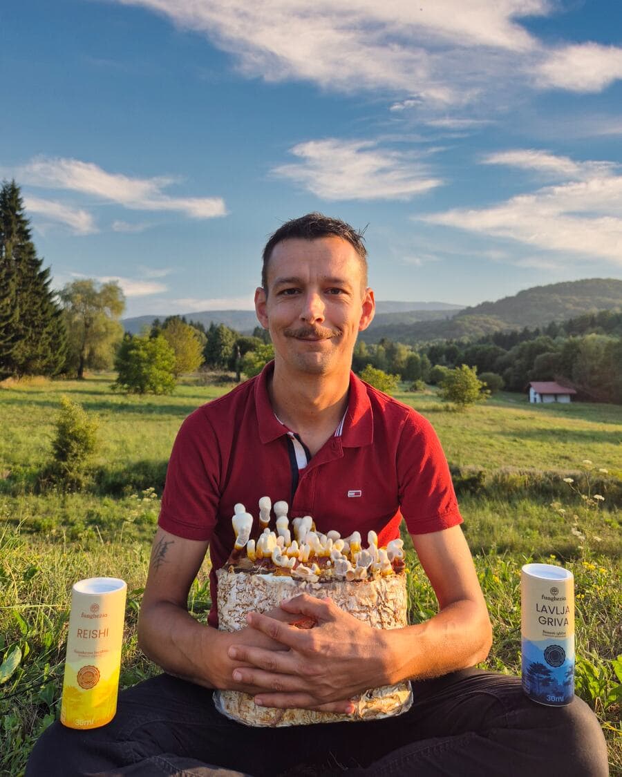 Čovjek drži gljive u prirodi, boce Reishi Lavlja Griva.